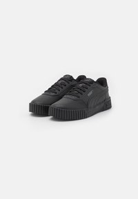 Zapatillas negras de cuero sintético con una superficie texturizada, con puntera redonda, diseño con cordones y suela de goma estriada.