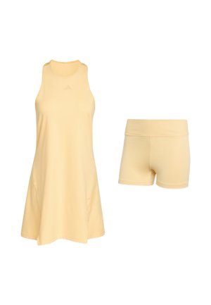 Gul atletik kjole med ærmeløs design, rund halsudskæring og blødt stof. Kombineret med matchende gule shorts.