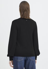 Czarny dziany sweter z okrągłym dekoltem i bufkowatymi długimi rękawami, z prążkowanymi mankietami i krawędzią. Gładka tekstura z minimalną ilością detali.