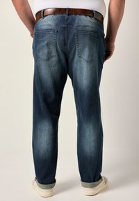 Mörkblå denimjeans med urtvättning, rak passform, uppvikta benslut, femficksdesign och ett brunt läderbälte.