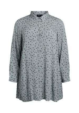 Svijetlozelena košulja dugih rukava s ovratnikom, koja ima prednji dio s gumbima i male crne cvjetne uzorke. Mekana tekstura tkanine.