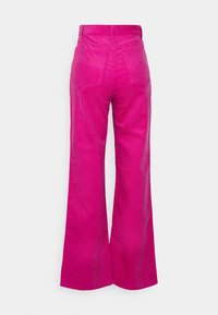 Pantalons en velours côtelé rose à jambes larges avec une taille haute, tissu texturé en côtes, deux poches arrière et une finition lisse au niveau de la ceinture.