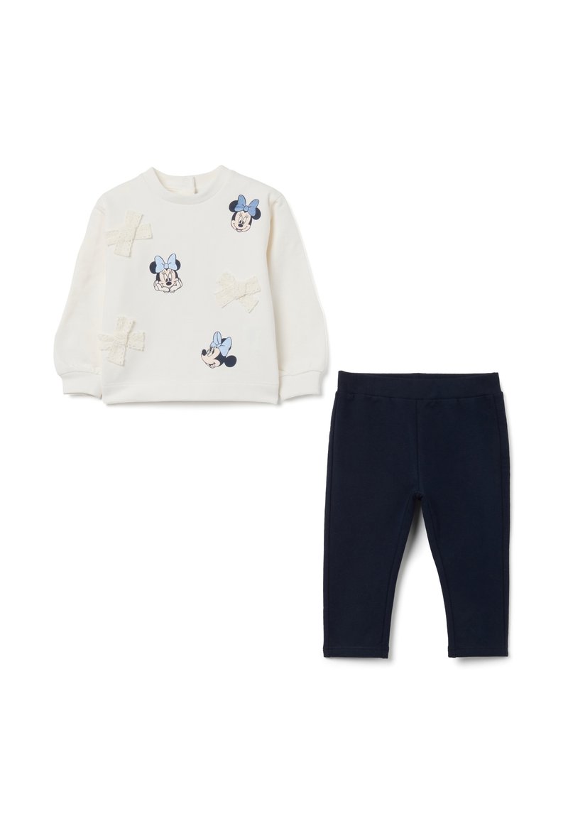 L'ensemble comprend un sweat-shirt crème avec des motifs de Minnie Mouse et des leggings bleu marine foncé. Le sweat-shirt est orné de nœuds brodés et est fabriqué dans un tissu doux.
