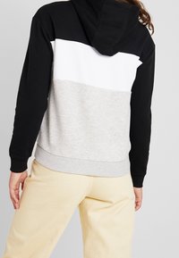 Sudadera con capucha que presenta bloques de color negro, blanco y gris, con un dobladillo y puños acanalados, hecha de una suave mezcla de algodón.