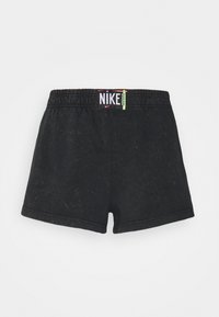 Svarta bomullsshorts med elastisk midja. En anmärkningsvärd logotag visar "NIKE" med färgglada accenter på midjan.