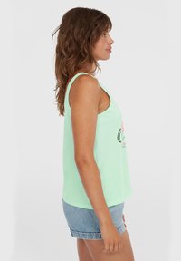 Mintgrünes ärmelloses Tanktop aus weichem Stoff mit einem lässigen Schnitt und rundem Ausschnitt, kombiniert mit Jeansshorts.