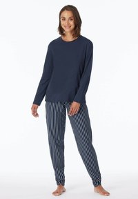 Navyblaues Langarmshirt in Kombination mit navygestreiften Hosen. Das Shirt ist einfarbig, während die Hose vertikale weiße Streifen aufweist. Bequemer Sitz.