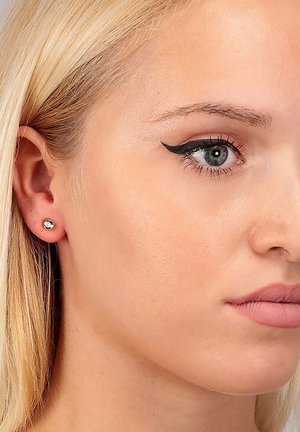 Stud earrings featuring a round, clear crystal set in a minimalist silver-tone mount, highlighting a simple and elegant design.