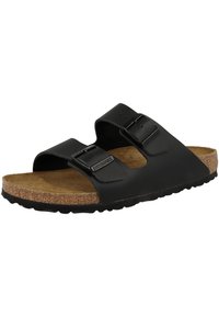 Sandales noires à enfiler avec deux boucles réglables, semelle en liège et semelle en caoutchouc texturé, présentant un design minimaliste et un matériau lisse.