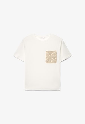 T-shirt bianca in cotone liscio con una patch beige all'uncinetto che presenta un motivo geometrico sul petto a sinistra. Maniche corte.
