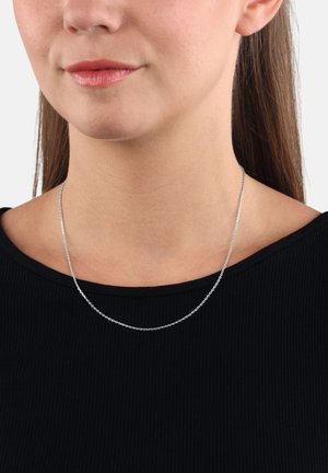 Collana in argento con piccoli anelli rotondi, indossata attorno al collo, poggiata su un top nero a righe. Texture liscia, design semplice.