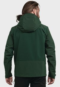 Green waterproof jacket with a fitted hood, textured fabric, and adjustable cuffs. Features a high collar and sleek design for mobility.