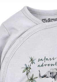 Grijze katoenen babypak met een olifantafbeelding en groene bladeren, met drukknoopsluitingen aan de zijkant en een ronde hals.