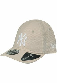 Beige Netz-Basketballkappe mit weißem gesticktem New York Yankees Logo, gebogenem Schirm und verstellbarem Riemen hinten.