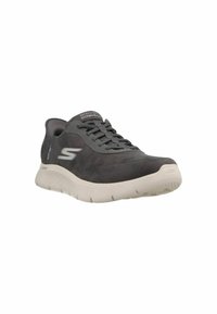 Schwarzer Sportschuh mit glattem Wildlederobermaterial, Schnürdesign, einem auffälligen Logo und einer hellgrauen strukturierten Sohle.