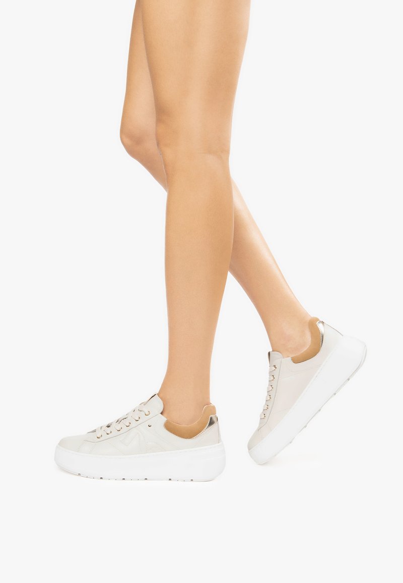 Beige sneakers met een gladde leren afwerking, voorzien van een contrasterende tan accent bij de hak en witte rubberen zolen met ronde veters.