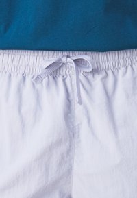 Lichtgrijze shorts met een elastische tailleband, voorzien van een trekkoordsluiting in een bijpassende kleur. Zachte textuur en minimalistisch ontwerp.