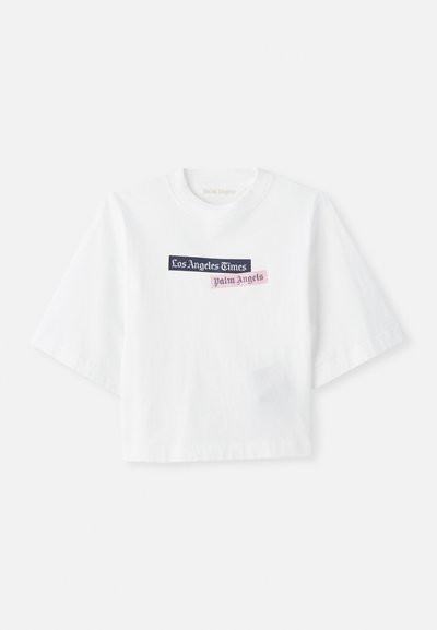 White cropped t-shirt made of cotton with a round neck. Features printed text "Los Angeles Times" and "Palm Angels" in various colors.