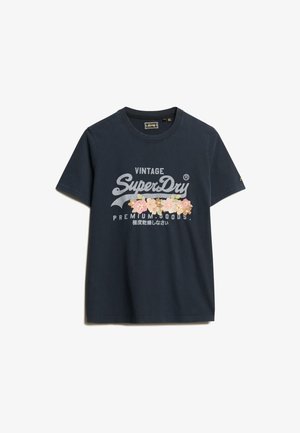 T-shirt in cotone blu navy con un grande logo stampato in bianco e ricamo floreale. Maniche corte e scollo rotondo.
