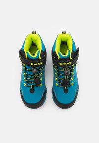 Blue hiking boots with black accents, yellow laces, and a padded collar. Features a rubber sole and adjustable strap for secure fit.