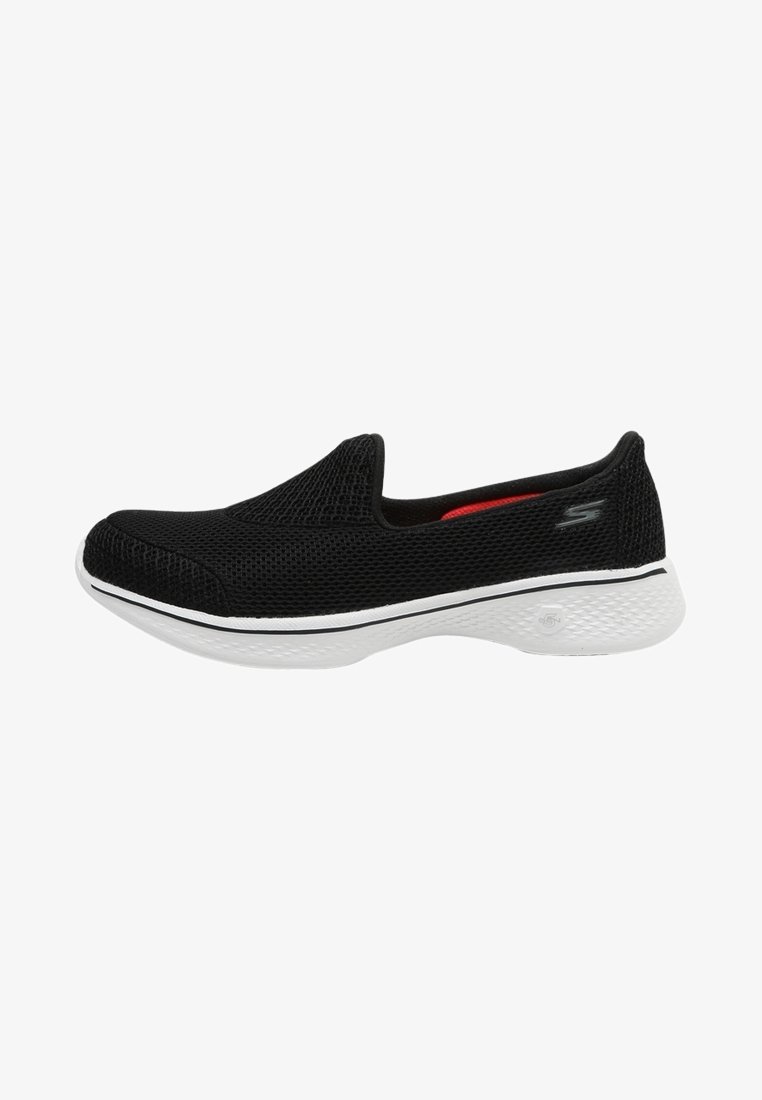 Baskets slip-on noires en mesh avec semelle blanche, talon bas et petit logo sur le côté, conçues pour un confort décontracté et une bonne respirabilité.