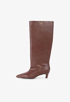 Braune Leder-Stiefel bis zum Knie mit spitzer Zehenform und niedrigem Absatz, der ein minimalistisches Design und ein kleines Logo-Detail nahe der Oberseite aufweist.