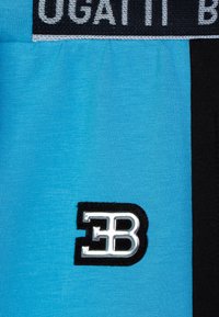 Blue fabric with a smooth texture features a black stripe and a prominent silver logo "EB" against a black background.