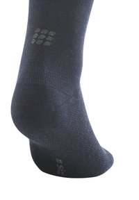 Dunkelgraue Socke aus strukturiertem Stoff, mit verstärktem Fersenbereich, Fußgewölbeunterstützung und Griffmustern an der Sohle für zusätzlichen Halt.