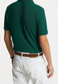 Zelená polo košile s krátkým rukávem vyrobená z bavlny, s texturovaným povrchem. Nosit s bílými denimovými džíny a hnědým koženým páskem.