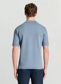 Graues Poloshirt mit kurzen Ärmeln, strukturierter Stoff und klassischem Kragen. Die Rückansicht zeigt ein sauberes Design und subtile Details.