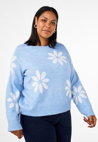 Hellblaues Sweater mit weißen Gänseblümchenmustern. Ausgestattet mit einem runden Halsausschnitt und gerippten Bündchen. Weiche Textur und lockere Passform, mit einem verkürzten Saum.