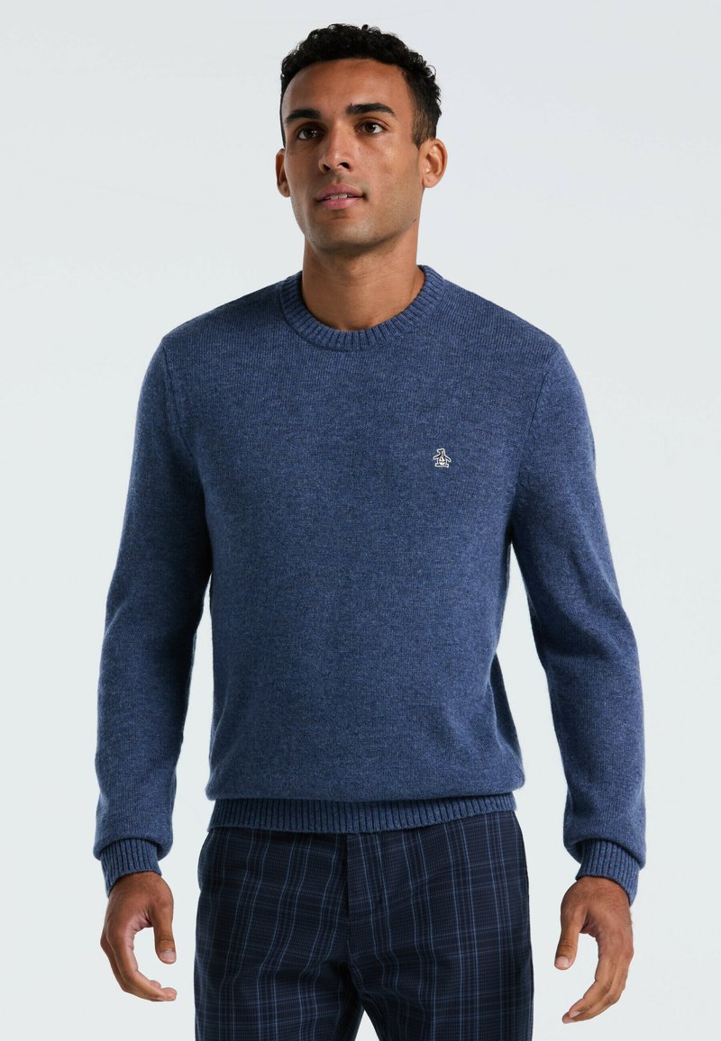 Marineblauwe gebreide trui met een ronde halslijn, geribde manchetten en een textuurafwerking. Heeft een klein logo op de borst.