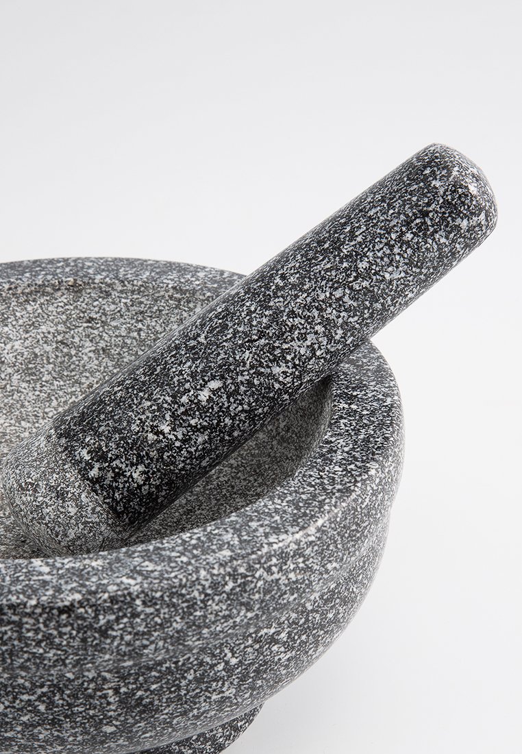 Granitmortel und -stößel, rundes Design, raue Oberfläche, grau mit schwarzen und weißen Sprenkeln. Der Stößel ist zylindrisch und verjüngt sich nach oben.