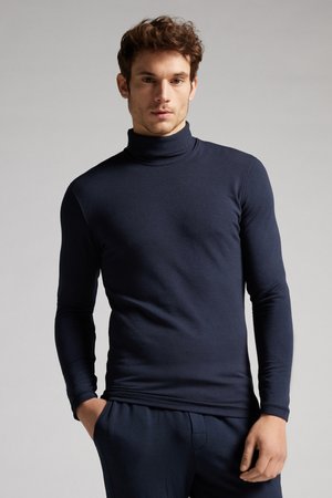Marineblauwe lange mouw turtleneck gemaakt van zachte stof, met een getailleerd ontwerp en een gladde textuur. Gemaakt om te dragen met bijpassende broek.
