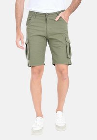 Pantaloni cargo color verde oliva realizzati in cotone, dotati di due tasche laterali e due tasche cargo, con una linea dritta e lunghezza sopra il ginocchio.