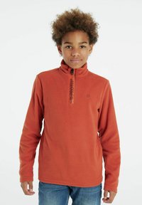 Maglione in pile color arancio bruciato con colletto alto, zip frontale a quarto e logo in evidenza. Tessuto morbido con maniche lunghe e vestibilità rilassata.