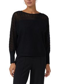 Maglione nero con texture a coste sul corpo e maniche trasparenti e strutturate. Presenta uno scollo rotondo e una vestibilità comoda.