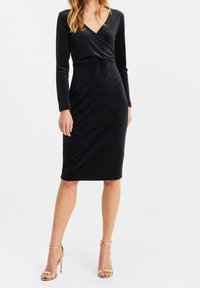 Musta pitkähiha Mekko, jossa on kietaisumalli ja vinoraitakuosi. Vyötäröä myötäilevä siluetti, joka päättyy juuri polven alapuolelle.