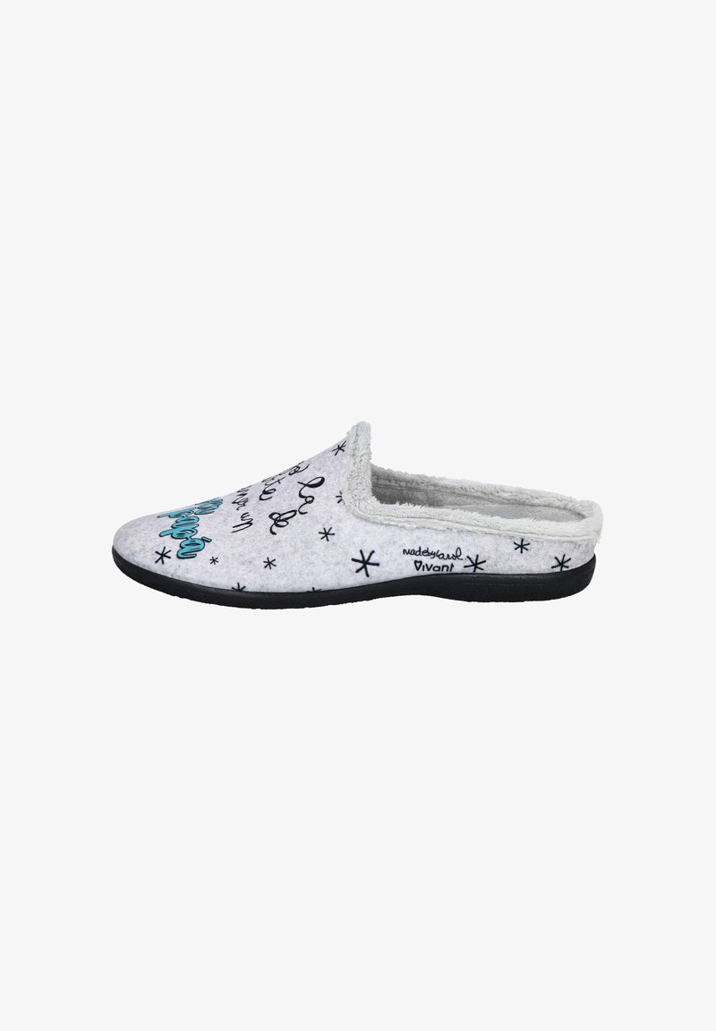 Pantufla gris claro con una textura suave, suela negra y patrones decorativos y letras en negro. Diseño tipo slip-on con la parte trasera abierta.