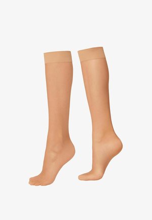 Calcetines altos color beige con una textura suave y una banda superior acanalada; la zona de los dedos está abierta, lo que permite una buena transpiración y comodidad.