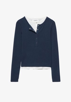 Tengerészkék hosszú ujjú ing fehér kerek gallérral és három patentos gombsort tartalmazó patentos záródással. Puha anyag, rövidített fazon és bordázott mandzsetták.