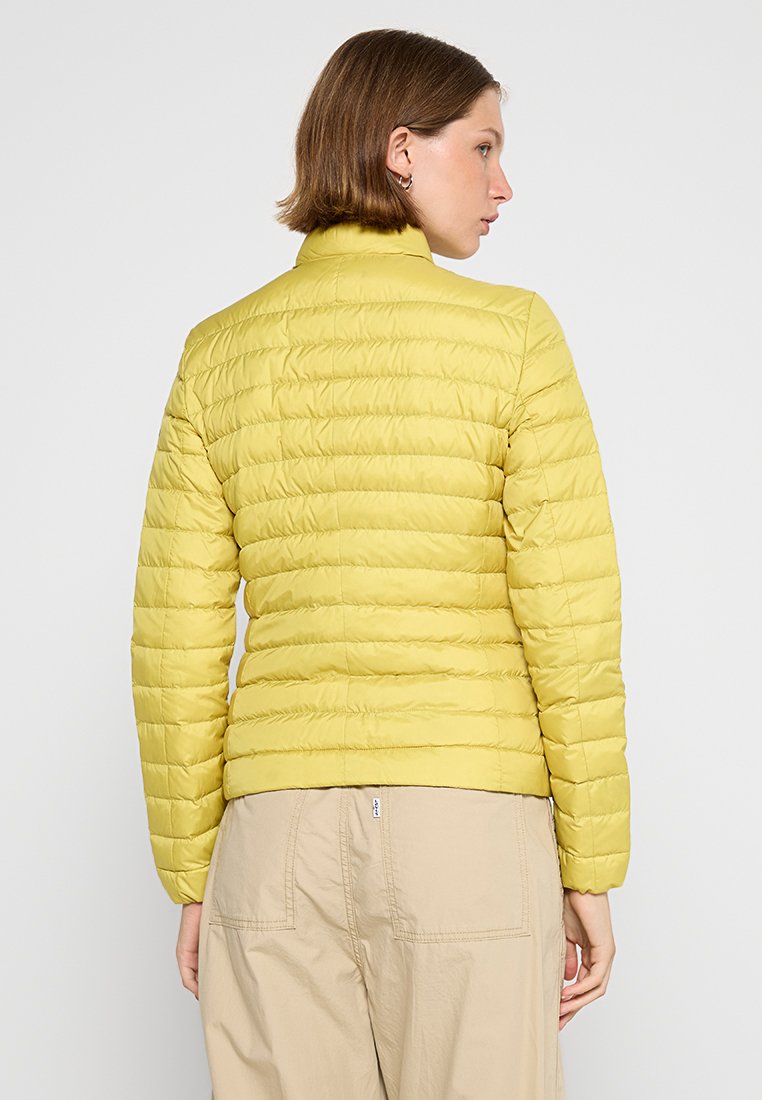Helle gelbe Steppjacke mit horizontalen Nähten, hohem Kragen und glatter Textur, von hinten betrachtet.