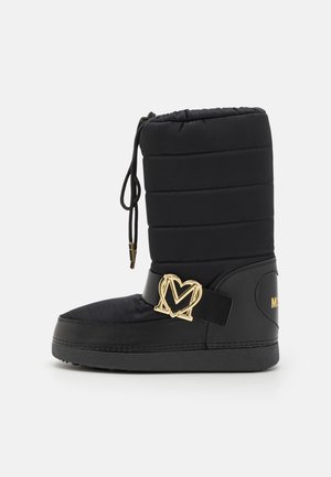 Crna zimska čizma s kvadratnim dizajnom, gumeni đon, podesiva vrpca i zlatni dodaci s logotipom sa strane.