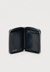 Πορτοφόλι Calvin Klein σε ναυτικό μπλε από δέρμα με φερμουάρ, πολλαπλές θήκες για κάρτες και ομαλή υφή. Στο εσωτερικό υπάρχει ένας μόνο χώρος.