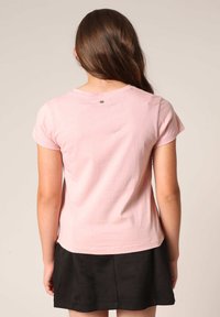Roze katoenen t-shirt met korte mouwen en een ronde halslijn, voorzien van subtiele stikdetails en een klein logo op de achterkant.