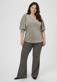 Haut à manches bouffantes, rayé argenté avec un col en V, associé à un pantalon large gris. Présente une brillance et une texture de tissu douce.