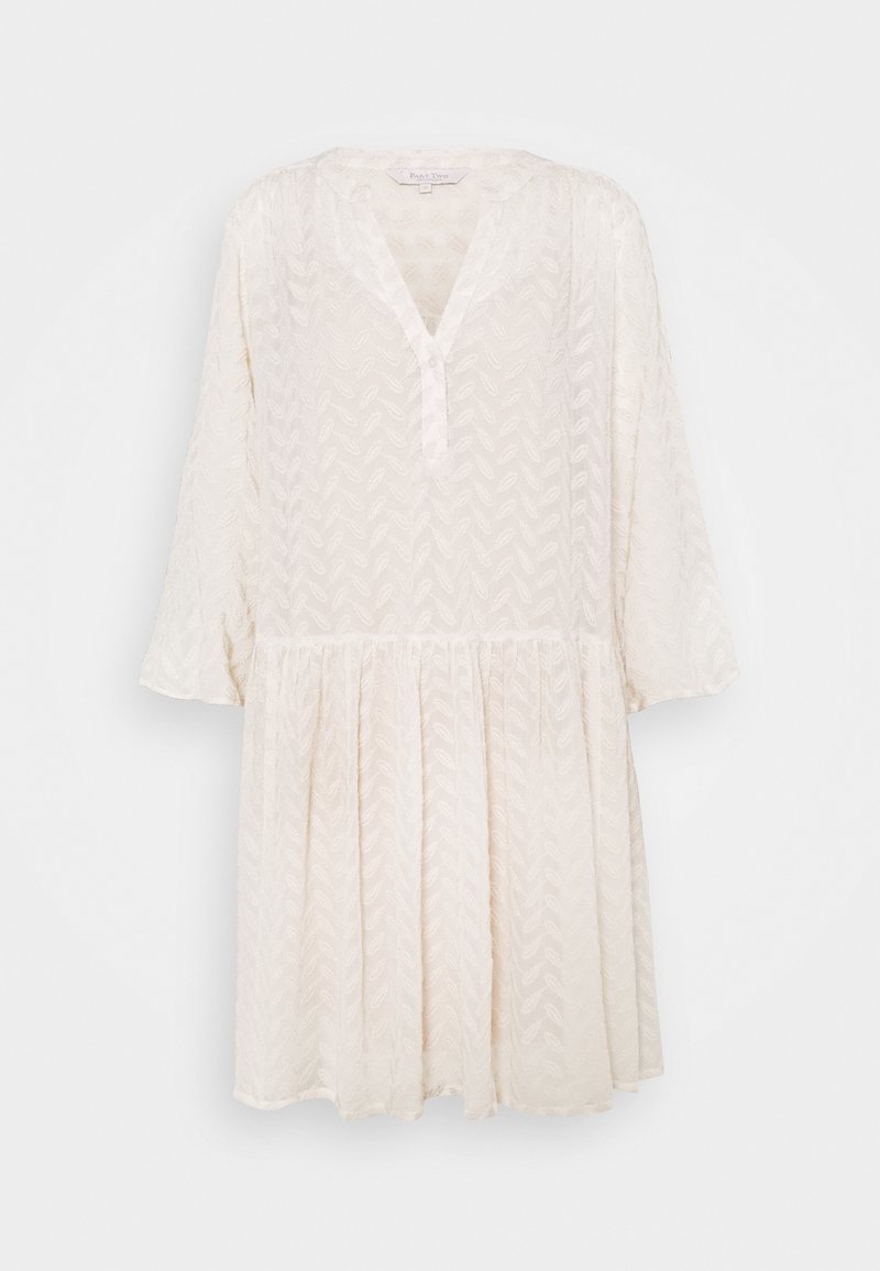 Robe texturée crème clair avec col en V, manches longues et taille froncée créant une jupe fluide et ample sur un fond uni.