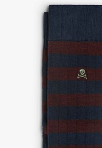 Calze a righe in blu navy e bordeaux, realizzate in tessuto morbido, con un piccolo logo di teschio e ossa incrociate in verde.