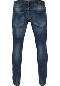 Tumed sinised teksad, slim fit lõikega, millel on kulunud viimistlus, kaks tagakotti ja bränditud vöökoht.