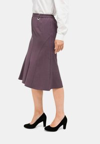 Lila ausgestellte Rock mit strukturiertem Finish, ausgestattet mit einem elastischen Bund mit einem runden Akzent. Kombiniert mit schwarzen High Heels.